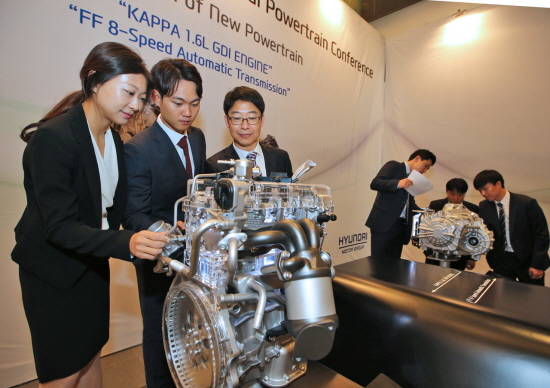 참석자들이 현대·기아차가 새롭게 선보인 카파 1.6L GDI 엔진(왼쪽)과 전륜 8속 자동변속기를 살펴보고 있는 모습. ⓒ 현대·기아차