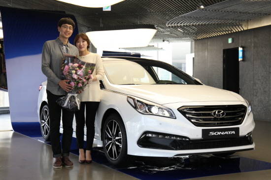현대모터스튜디오에서 쏘나타 와일드 버건디와 함께한 1호차 고객 홍일강씨와 아내 윤소혜씨. ⓒ 현대자동차