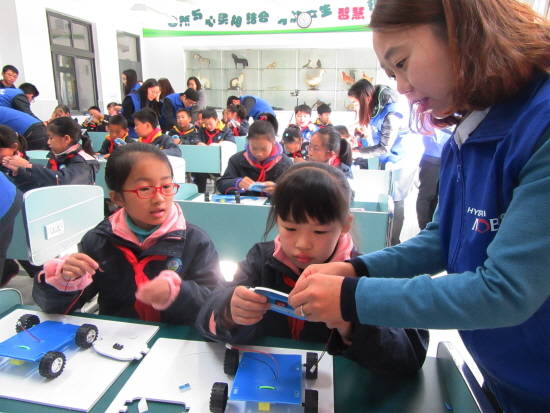 구정 소학교에서 상해모비스 직원 자원봉사자들이 학생들을 도와 '장애물을 만나면 멈추는 자동차' 실습을 진행하고 있는 모습. ⓒ 현대모비스