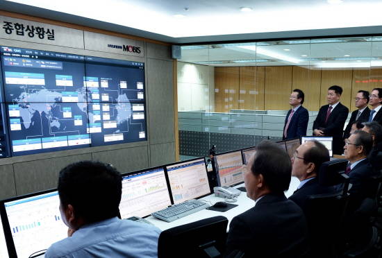현대모비스 본사 종합상황실에서 1차 협력사 대표들과 현대모비스 관계자들이 '시스템경영 시연'을 참관하며 실시간 글로벌 생산 현황을 살펴보고 있다. Ⓒ 현대모비스