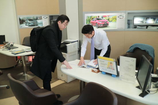 차량을 인도받기 위해 지점을 방문한 박동식 씨(왼쪽)와 이정훈 팀장. = 노병우 기자