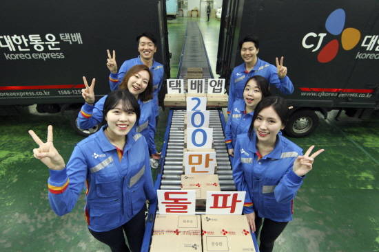 CJ대한통운 신입사원들이 택배앱 다운로드 200만 돌파를 자축, 택배터미널에서 포즈를 취하고 있는 모습. ⓒ CJ대한통운