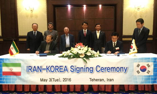 바박 아흐마디 이란 철도청 부청장(왼쪽)과 김승탁 현대로템 사장이 강호인 국토교통부 장관(뒷줄 왼쪽 네 번째)이 배석한 가운데 협약서에 사인하고 있는 모습. ⓒ 현대로템