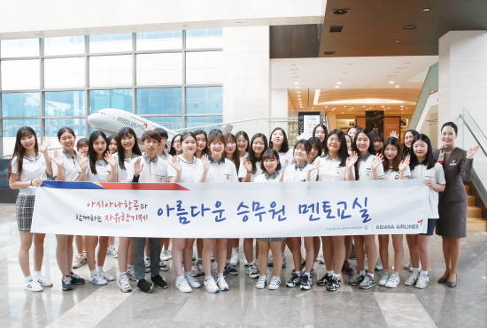 '아름다운 승무원 멘토 교실' 행사에서 캐빈승무원과 참여한 학생들이 기념사진을 촬영하고 있는 모습. ⓒ 아시아나항공
