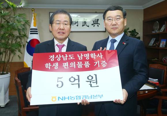 김진국 NH농협 경남본부장(오른쪽)이 홍준표 경남도지사에게 남명학사 물품비 5억원을 전달하고 있다. ⓒ 경남도청