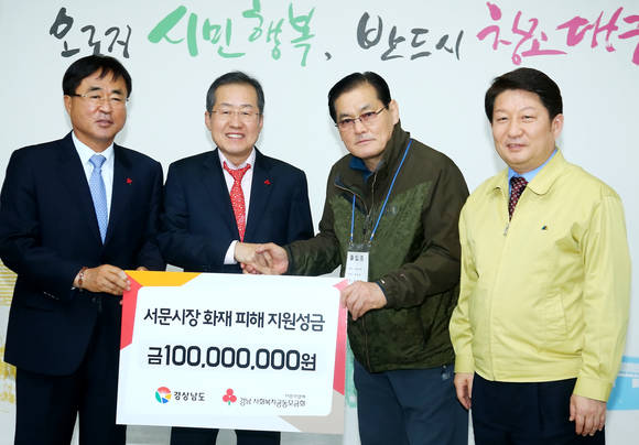 홍준표 경남도지사와 한철수 경남사회복지공동모금회장이 대구 서문시장 화재 복구지원비 1억원을 전달하고 있다. ⓒ 경남도청