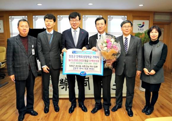 장흥군인재육성장학금의 수혜를 받아 자녀를 키운 사춘근(오른쪽 3번째)씨가 자녀들을 대신해 김성 장흥군수에게 장학금을 전달하고 있다. = 장흥군