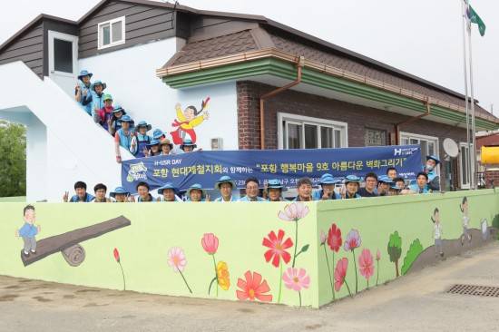 지난 23일 봉사활동에 참가한 봉사자들이 자신들이 그린 벽화 앞에서 기념촬영을 하고 있다. ⓒ 현대제철