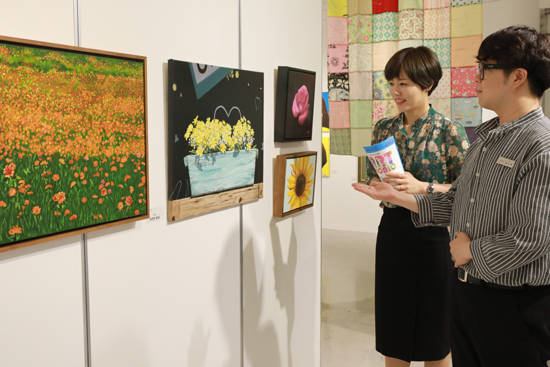 롯데백화점광주점 11층 롯데갤러리를 찾은 고객들이 벽에 걸린 문화센터 회원들의 작품을 감상하고 있다.ⓒ롯데백화점광주점