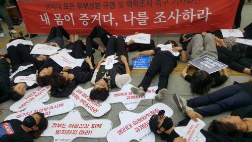 생리대 전 성분 조사와 역학조사 실시 촉구 기자회견에서 여성환경연대 회원을 비롯한 참가자들이 검은 옷을 입고 '내몸이 증거다' 다이 인(Die-in) 퍼포먼스를 하고 있다. = 하영인 기자