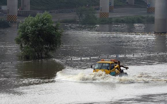 물 위의 노란 색 저것은 배가 아니라 자동차예요. 비가 많이 와서 길이 보이지 않아요. ⓒ 뉴스1