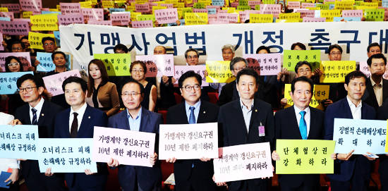 지난 6일 국회 의원회관에서 열린 전국가맹점주협의회연석회의 가맹사업법 개정 촉구대회에서 이학영 더불어민주당 을지로위원장(앞줄 오른쪽부터)과 정세균 국회의장, 이재광 연석회의 공동의장, 우원식 더불어민주당·노회찬 정의당 원내대표, 지상욱 바른정당 의원, 김상조 공정거래위원장 등 참석자들이 피켓을 들고 있다. ⓒ 뉴스1