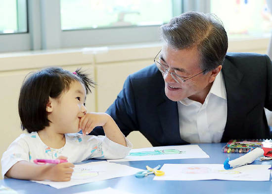 문재인 대통령이 지난 8월9일 건강보험보장강화 현장 방문으로 서울 서초구 서울성모병원을 찾아 병원 내 어린이학교에서 환우와 인사하고 있다. ⓒ 청와대 제공