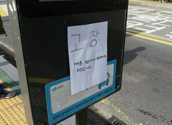 고장난 버스알림판에 '빠른 시일 내에 수리하도록 하겠습니다'라는 글을 적은 종이가 붙어 있다. 구청 담당공무원이 적어 놓은 것으로 보인다. = 김노아