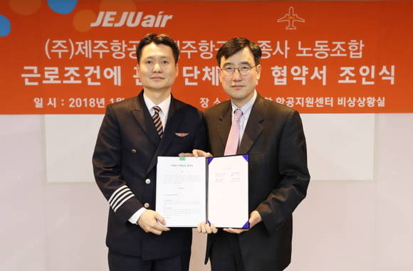 이석주 제주항공 대표이사(오른쪽)와 최정민 제주항공 조종사노동조합 위원장이 근로조건에 관한 단체 협약서에 서명한 후 기념촬영을 하고 있다. ⓒ 제주항공