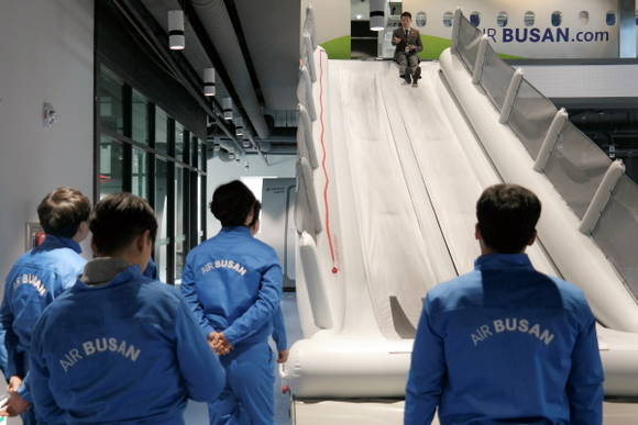 10일 에어부산 사옥에서 실시한 소방관 대상 비상상황 교육에서 에어부산 안전교관이 비상탈출 슬라이드에 대해 설명하고 있다. ⓒ 에어부산