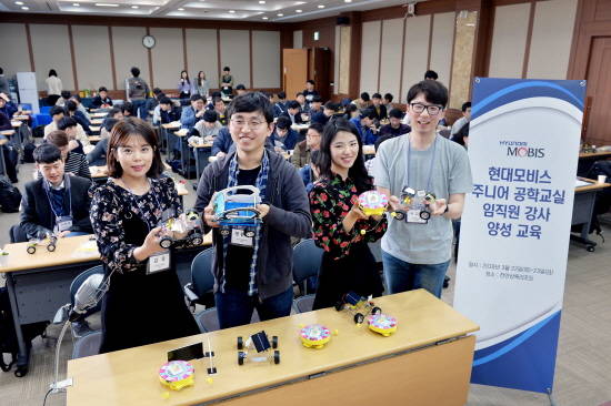 현대모비스 직원 주니어공학교실 강사들이 한국공학한림원과 한양대 청소년 과학기술진흥센터 소속 강사진들의 설명을 들으며 만든 어린이 과학 키트를 들어보이고 있다. ⓒ 현대모비스