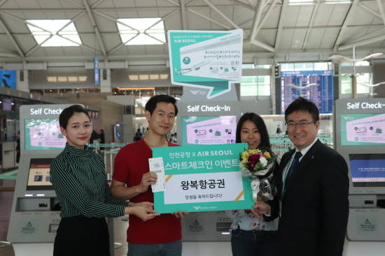 인천국제공항 셀프 체크인 이벤트에 당첨된 고객이 기념사진을 찍고 있다. ⓒ 에어서울