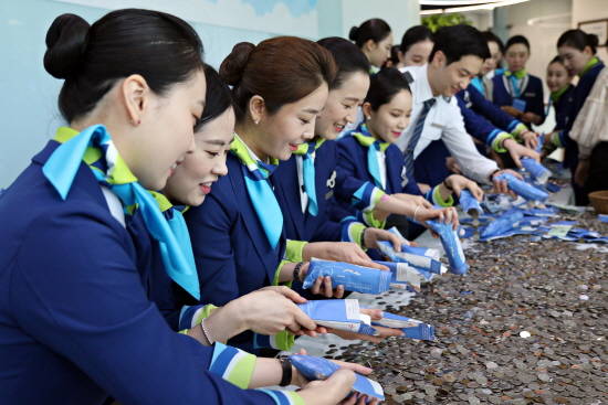 에어부산 캐빈승무원들이 '사랑의 동전모으기 캠페인' 5차 개봉식에서 봉투를 개봉하고 있다. ⓒ 에어부산