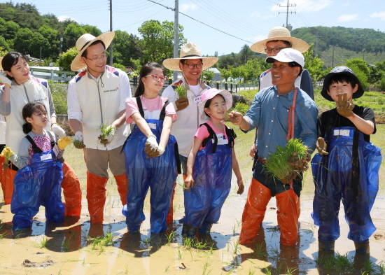 활동에 참가한 임직원 및 임직원 가족들이 모내기 전 이기석 외삼포 2리 이장(오른쪽에서 두번째)으로부터 모내기 방법에 대한 설명을 듣고 있다. ⓒ 아시아나항공