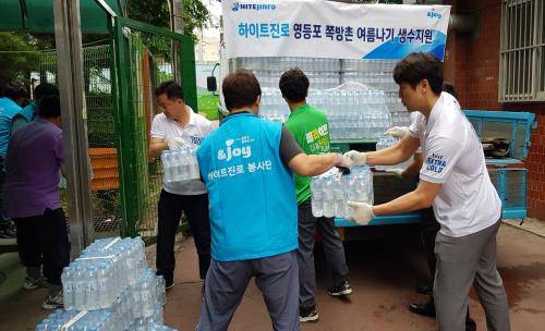 하이트진로 임직원들이 쪽방촌 거주민들에게 생수를 전달하고 있다. ⓒ 하이트진로