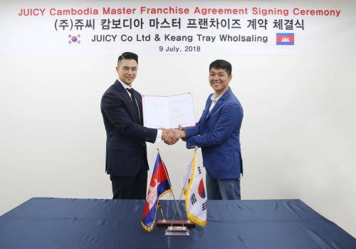 쥬씨 캄보디아 마스터프랜차이즈 계약 체결식에서 윤석제 쥬씨 대표(왼쪽)와 뜨라이 뿌틴 나인닷츠 이사가 기념 촬영하고 있다. ⓒ 쥬씨