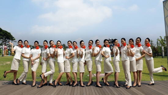 제주항공 신입승무원들이 김포공항 내 잔디밭에서 새로 지급받은 유니폼과 구두를 착용하고 기념촬영을 하고 있는 모습. ⓒ 제주항공