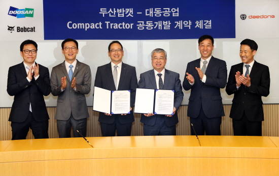 두산밥캣 스캇성철박 사장(사진 왼쪽에서 3번째)과 하창욱 대동공업 사장(사진 왼쪽에서 4번째)이 콤팩트 트랙터 공동개발 계약을 체결하고, 기념사진을 촬영하고 있다. ⓒ 두산밥캣