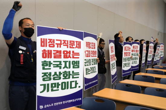 지난 5월 한국GM 비정규직지회 조합원들이 부평공장 홍보관에서 손팻말을 들고 기습시위를 하고 있는 모습. ⓒ 뉴스1