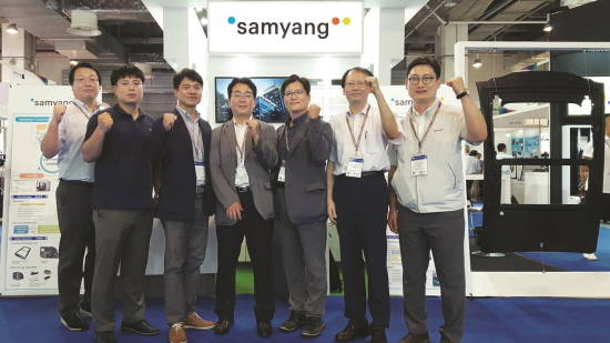 삼양사 조성환 화학연구소장(우측 세번째)이 상해 복합소재 전시회에서 C-LFT로 만든 자동차 선루프 프레임(사진 가장 우측)을 내세운 전시 부스를 배경으로 기념촬영을 하고 있다. ⓒ 삼양홀딩스