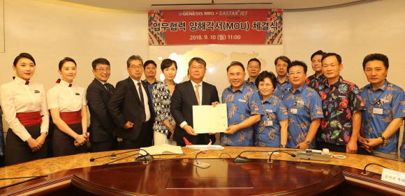 이스타항공과 제너시스 BBQ그룹이 업무협약을 체결하고 양사 관계자들이 모여 기념사진을 촬영하고 있는 모습. ⓒ 이스타항공