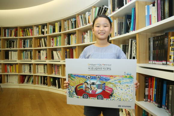 대상에 선정된 홍지율 양이 '시각장애인의 눈이 되어주는 자동차' 그림 작품을 들고 있는 모습. ⓒ 현대자동차