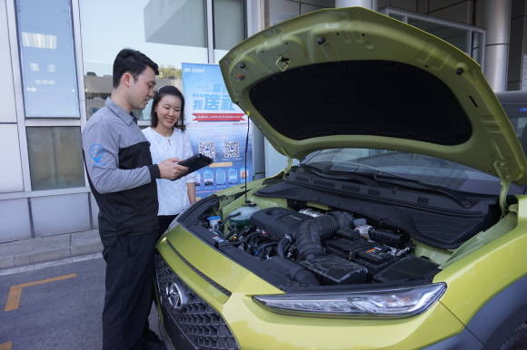 북경현대 딜러 정비사가 고객과 차량을 점검하고 있는 모습. ⓒ 현대자동차