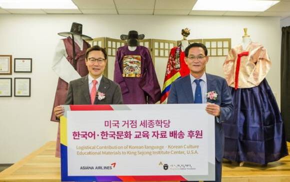 김영헌 아시아나항공 미주지역본부장(왼쪽)과 세종학당재단 이사장을 대신하여 온 권오기씨(오른쪽)가 한국어 교육자료를 전해주며 같이 사진을 찍었어요. ⓒ 아시아나항공