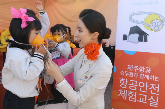 항공안전체험교실에 참여한 어린이들에게 비상상황 발생 시 산소마스크 및 구명복 착용방법을 가르쳐 주고 있다. ⓒ 제주항공