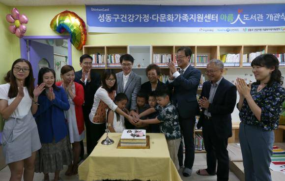 지난 8월 서울 홍익동 성동구 건강가정 다문화가족 지원센터에서 열린 473번째 아름인 도서관 개관식에서 주철수 신한은행 부행장(왼쪽 4번째), 정원오 성동구청장, 이정숙 성동구 건강가정 다문화가족 지원센터장, 최인선 신한카드 부사장, 박두준 아이들과미래재단 상임이사 등이 어린이들과 기념케이크를 자르고 있다. ⓒ 신한카드