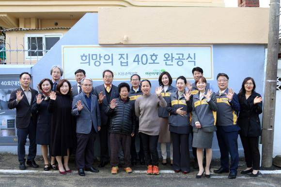 양종희 KB손해보험 사장(2열 오른쪽 세 번째)과 이제훈 초록우산어린이재단 회장을 비롯한 KB손해보험 및 재단 임직원들이 새롭게 지어진 40번째 희망의 집 앞에서 수혜 가족과 함께 기념 촬영하고 있다. ⓒ KB손해보험