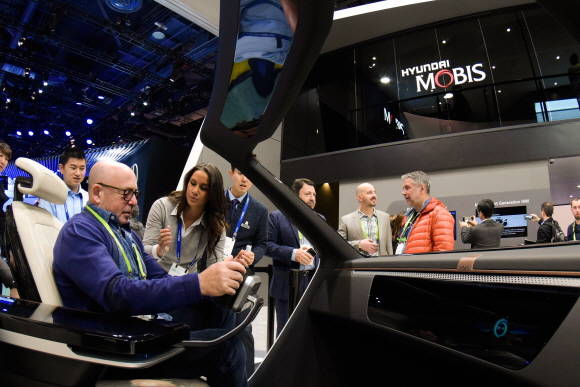 올해 1월 미국 라스베가스에서 열린 2018 CES에서 현대모비스 부스를 찾은 관람객이 연구원의 설명을 들으며 전시품을 체험해보고 있다. ⓒ 현대모비스