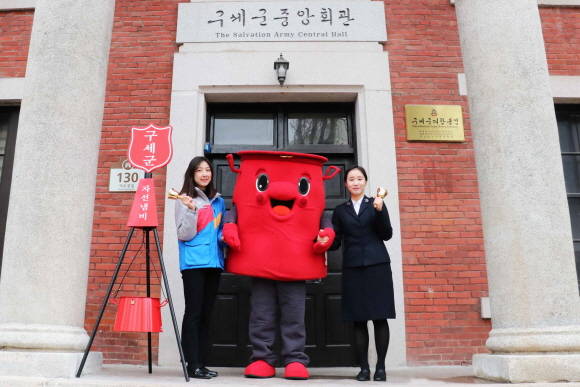 CJ대한통운 직원(왼쪽)과 구세군 직원이 구세군 캐릭터인 '따끈이'와 함께 기념촬영을 하고 있다. ⓒ CJ대한통운