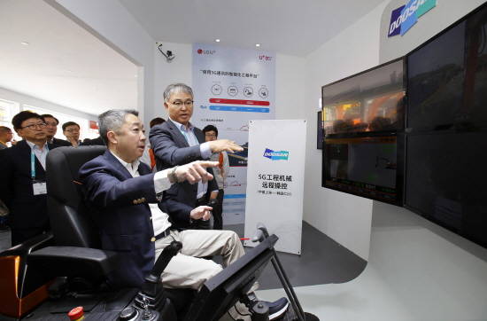 박정원 두산그룹회장이 29일 중국 상하이에서 열리고 있는 국제건설기계전시회 '바우마 차이나' 두산인프라코어 부스를 찾아 5G 원격제어 기술을 사용해 인천공장에 있는 굴삭기를 직접 작동하고 있다. ⓒ 두산