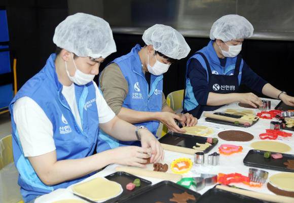 신한생명은 지난 2011년부터 1004DAY 봉사대축제를 전개해오고 있다. 신한생명 직원봉사자들이 지역사회 저소득층 어린이들을 위해 쿠키를 만들고 있는 모습. ⓒ 신한생명