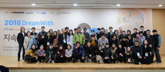 2018 드림위드 성과공유회 행사현장에서 한국타이어나눔재단 관계자 및 드림위드 단체별 대표자와 지역주민들이 기념촬영을 하고 있다. ⓒ 한국타이어