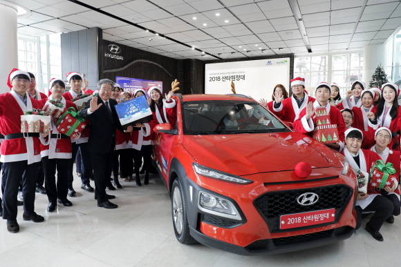 최불암 초록우산 어린이재단 후원회장과 산타원정대가 루돌프 장식을 한 코나와 함께 기념촬영을 하고 있는 모습. ⓒ 현대자동차