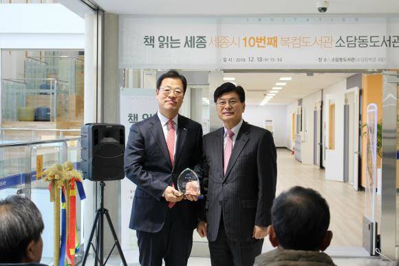 소담동 복합커뮤니케이션센터에 아름인 도서관을 개관했다. 최인선 신한카드 부사장(왼쪽)과 이춘희 세종시장이 기념촬영하고 있다.