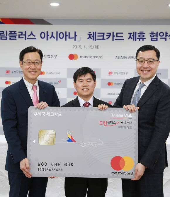 서울중앙우체국에서 아시아나항공 김영헌 여객본부장(왼쪽), 우정사업본부 신대섭 예금사업단장(가운데), 마스터카드코리아 최동천 대표(오른쪽)가 드림플러스 아시아나 체크카드 출시를 위한 업무협약식 후 기념사진 촬영을 하고 있다. ⓒ 아시아나항공