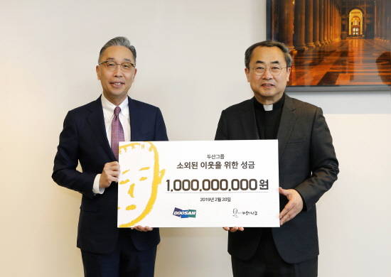 박지원 두산그룹 부회장(왼쪽)이 지난 20일 서울 명동성당에서 손희송 재단법인 '바보의나눔' 이사장에게 성금 10억원을 전달했다. ⓒ 두산