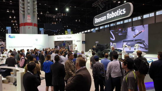 두산로보틱스가 미국 시카고에서 열리는 '오토메이트 2019'에 참가해 두산 협동로봇을 미국 시장에 처음으로 선보였다. 협동로봇 여섯 대가 고급 스포츠카를 둘러싸고 펼친 자동차 복합 솔루션 시연을 관람객들이 흥미롭게 지켜보고 있다. ⓒ 두산로보틱스