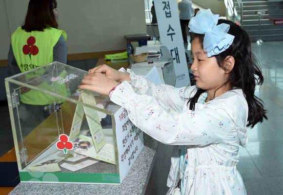 한 어린이가 캠페인에 참여해 고사리손으로 난치병학생 돕기 모금 성금에 동참하고 있다. ⓒ 부산교육청