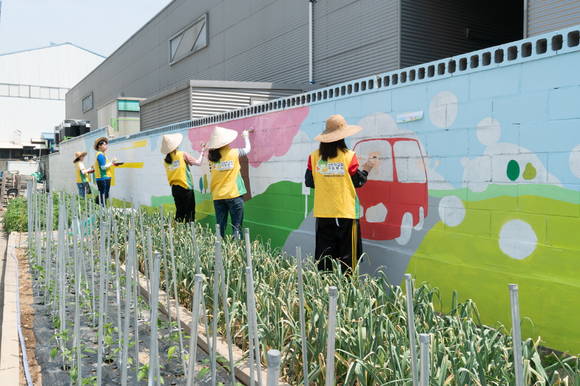 신천지자원봉사단 부산동부지부가 한국교통안전공단 사하자동차검사소 담벼락에 벽화봉사를 하고 있다. ⓒ 부산동부지부