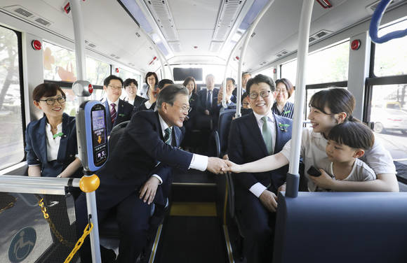 문재인 대통령이 5일 오후 경남 창원 컨벤션센터에서 환경의 날 기념식을 마친 후 수소 버스를 타고 도심형 수소 충전소로 이동하며 동승자들과 인사를 나누고 있다. ⓒ 연합뉴스